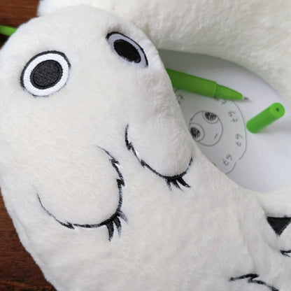 Detail of Brushbuddy neck pillow with a special seal and magic wand in the background.