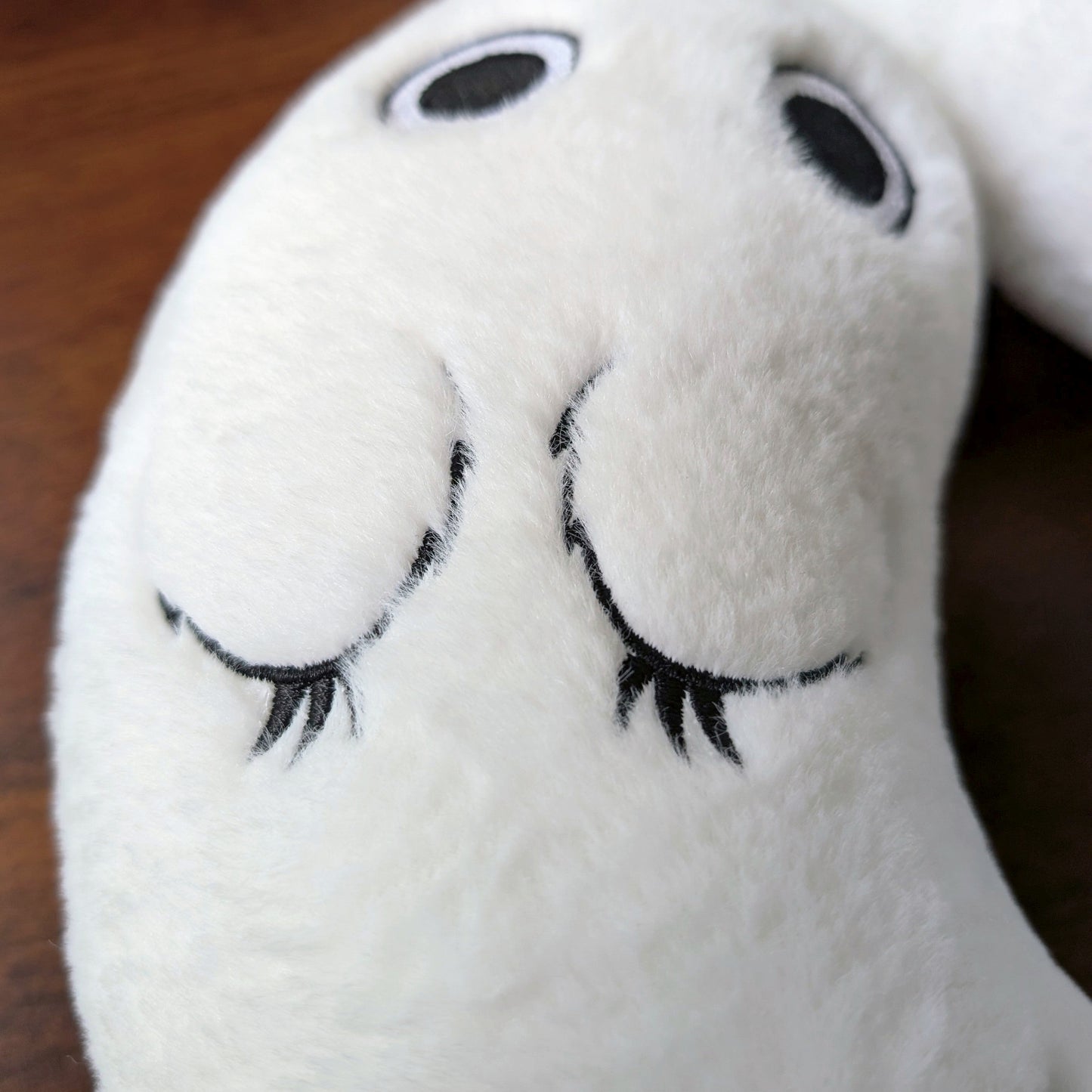 Detailed view of Brushbuddy neck pillow's embroidered front paws