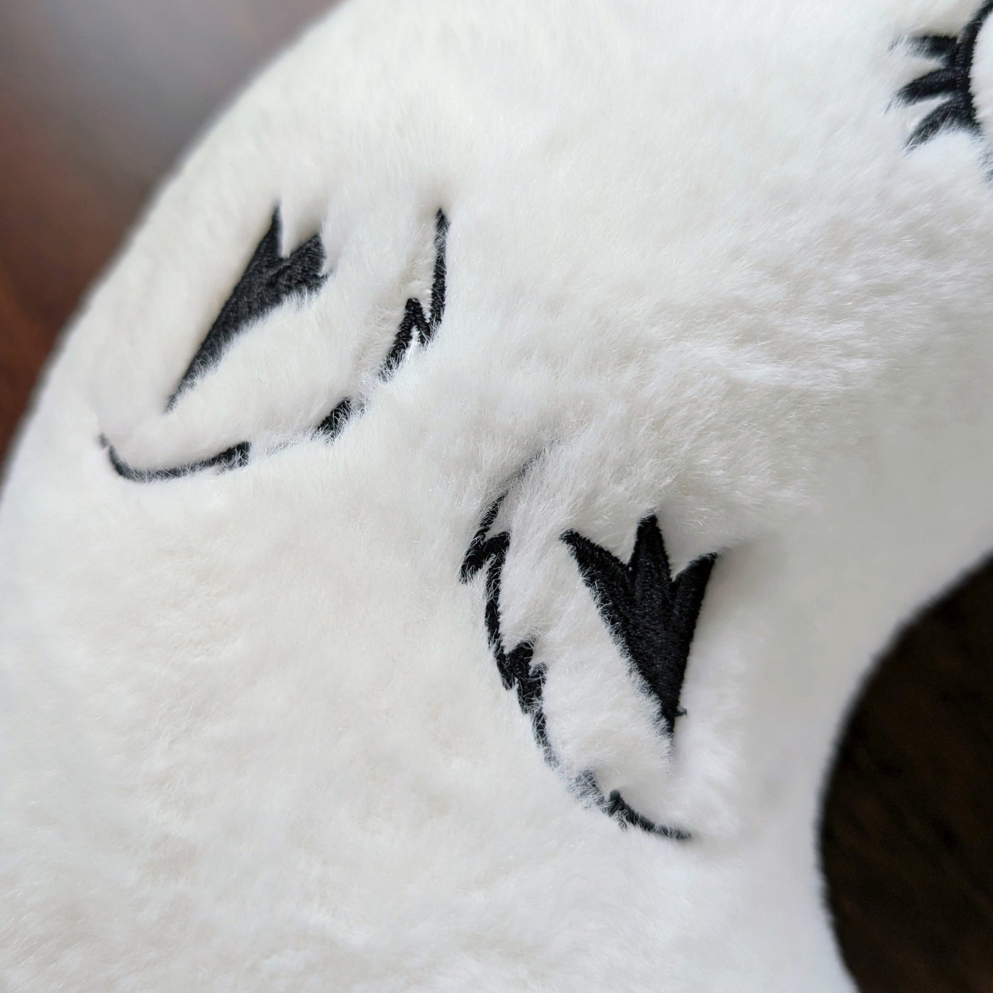 Detailed view of Brushbuddy neck pillow's embroidered rear paws